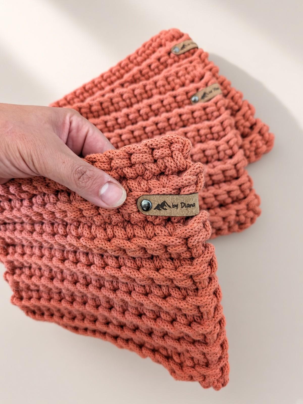 Hand fanning out terracotta crochet hot pads